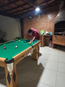 阿拉亚尔-杜卡布Varandas do Arraial- Hostel的男人在带台球桌的房间里打台球