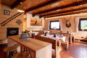 苏特廖Baita da Rico Zoncolan的餐厅设有木桌、椅子和壁炉