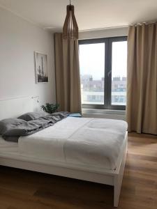 格丁尼亚UniQue 106的卧室设有一张白色的床和大窗户
