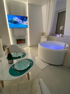 米卢斯Esprit MALDIVES ...... SPA LOVE au coeur de Mulhouse的白色的浴室设有浴缸和带玻璃杯的桌子