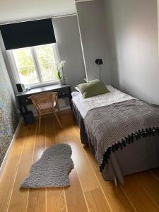TimmernabbenVilla Löfström的一间卧室配有一张床、一张桌子和一张地毯。