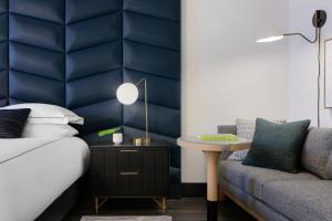 亚特兰大Kimpton Shane Atlanta, an IHG Hotel的一间卧室配有一张床、一张沙发和一张桌子