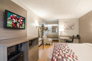 达拉姆红屋顶达勒姆酒店 - 三角公园的配有一张床和一台平面电视的酒店客房