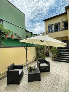拉文纳Domus Silvana Apartments的庭院配有两把椅子和一把遮阳伞