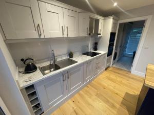 斯莱戈Sea View Lodge的厨房铺有木地板,配有白色橱柜。