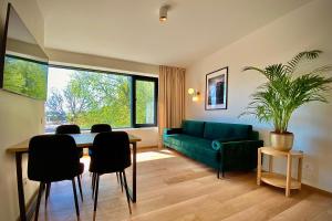 帕兰加SIRENA的客厅配有绿色沙发、桌子和椅子