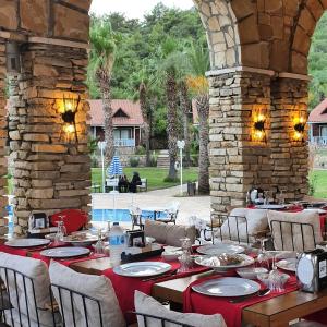 阿德拉桑阳光村庄俱乐部酒店的一间带桌椅和石墙的用餐室