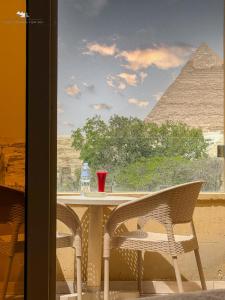 开罗Giza Pyramids View Inn的享有金字塔景致的桌椅