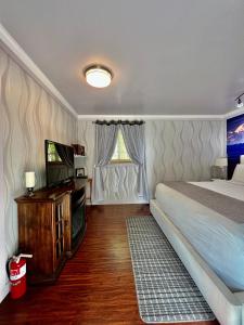 塔尔基特纳Sunshine Cottage的一间卧室配有一张床和一台平面电视