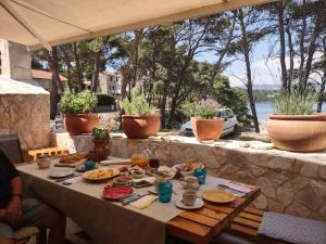 耶尔萨Stone Villa Hvar Ana and Nikola Beachfront的一张桌子,上面有食物,享有水景