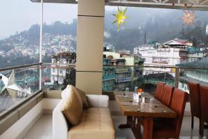 甘托克Mann Dechen and Palmo, Mg Marg, Gangtok的一间带桌子并享有城市美景的餐厅