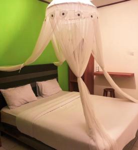 BajawaSilverin Bajawa的卧室配有2张床和白色蚊帐