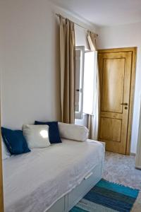 皮佐Apartment Casa Beatrice的一间卧室配有一张带蓝色枕头的床和一扇门