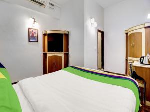 奇克马格尔Treebo Trend Benaka Residency的一间卧室配有一张带绿色和白色毯子的床