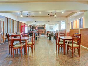 奇克马格尔Treebo Trend Benaka Residency的用餐室配有木桌和椅子
