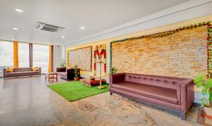 奇克马格尔Treebo Trend Benaka Residency的带沙发和砖墙的客厅