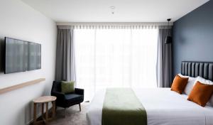 堪培拉娜拉邦达住宅酒店的配有一张床和一把椅子的酒店客房