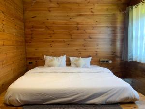 西姆拉Sugar Cube Retreat的卧室配有一张白色的木墙床