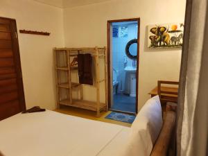 江比阿Jambiani Guest Lodge PEMBA的一间带一张床的卧室和一间带镜子的浴室