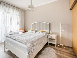 泰奇尔斯伯格阿沃斯Apartment in Carinthia on Lake Woerthersee的白色的卧室设有白色的床和窗户。