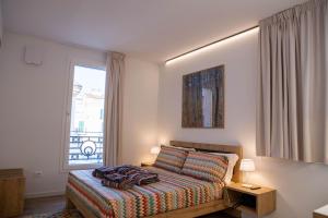 圣贝内代托-德尔特龙托Vespasiani SUITES & APARTMENTS的卧室在窗户前配有一张床