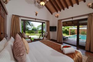 库玛拉孔Gokulam Grand Resort & Spa, Kumarakom的一间带大床的卧室和一个游泳池