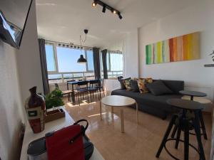 贝纳尔马德纳Apartamento DIORAMA D con impresionante vista, piscina y parking的客厅配有沙发和桌子