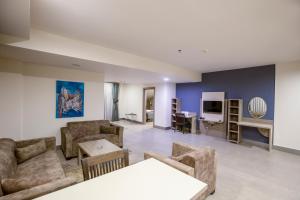 萨卡里亚Sen Otel的带沙发、桌子和电视的客厅