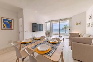 波连萨港Beachfront Apartment Sivella Mar的用餐室以及带桌椅的起居室。