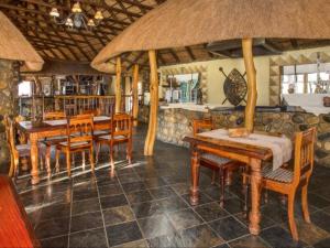 MkuzeMkuze Falls Private Game Reserve的用餐室配有木桌和椅子