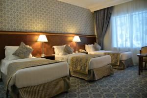 麦地那诺佐尔皇家酒店的酒店客房设有三张床和窗户。