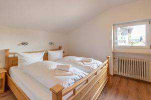 费斯恩Schöne Aussicht的一间卧室配有一张带白色床单的床和一扇窗户。