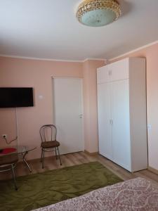 里加Smilgas的卧室配有白色橱柜和椅子