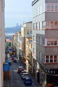 费罗尔Apartamento en centro de Ferrol的一条城市街道,汽车停在大楼旁边