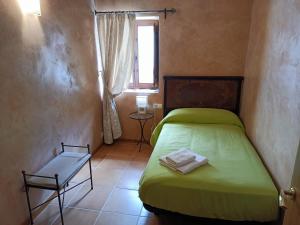 CastellfortCasa sala pinta的一间小卧室,配有绿色的床和窗户