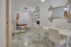 塞维利亚TWO BEDROOMS Leonor Dávalos的一间配备有白色桌椅的用餐室