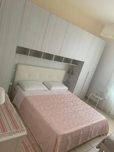 加利波利Residence Massilor的一间卧室配有一张带粉红色床单的大床