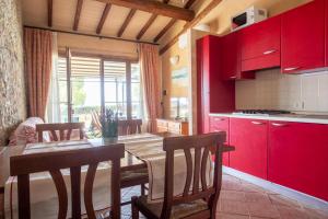 里奥托尔托Appartamento Palmaiola的厨房配有红色橱柜和桌椅