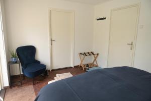 蒂尔堡AaBenB appartement的一间卧室配有蓝色的床和椅子