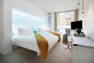 伦敦St Martins Lane London的酒店客房设有一张白色大床和一张书桌