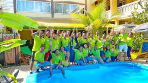 马哈赞加马任加可可酒店及餐厅的一群穿着绿色衬衫的人,在游泳池旁边