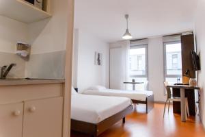 贝桑松勒斯奥特杜沙扎尔禅都公寓式酒店的一间小房间,配有两张床和厨房
