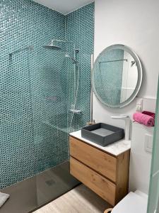 英格兰海滩Bungalow Yumbo的带淋浴、盥洗盆和镜子的浴室