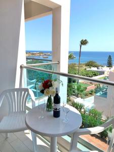 赫索尼索斯Saradari Beach Hotel - Adults Only的阳台上的桌子上摆放着两杯酒杯和鲜花