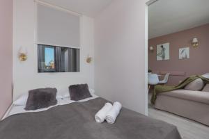 华沙Apartaments Solec 79 by Renters的一间卧室,床上有白色的鞋