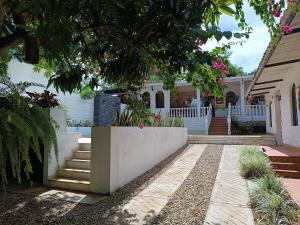 梅尔加Villa Clara Casa Campestre, Piscina, Naturaleza, Paseo de Río的一栋带白色围栏和楼梯的房屋