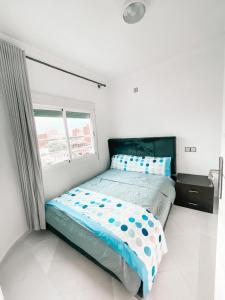 萨伊迪耶Hôtel champ élysée的一间卧室配有一张带蓝色床单的床和一扇窗户。