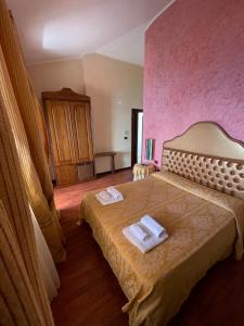 梵蒂冈角卡里斯佩拉村公寓酒店的一间卧室配有一张床,上面有两条毛巾