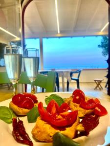 Marina PortoCasa La Quercia的餐桌上带西红柿的盘子和酒杯