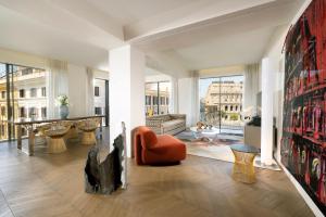 罗马Hotel Palazzo Manfredi – Small Luxury Hotels of the World的客厅配有橙色椅子和桌子